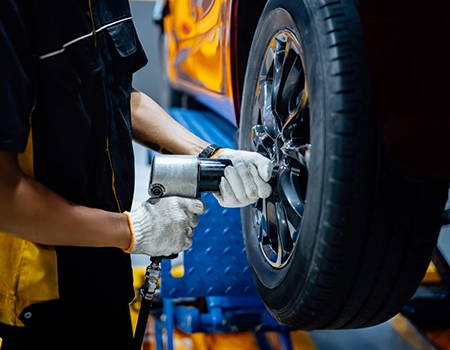 A photo of a person attaching a wheel to a car
